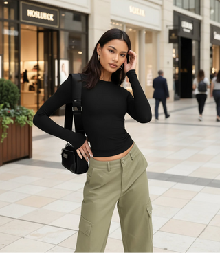 Woman wearing black fitted long sleeve top styled with olive trousers