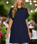 Woman wearing navy button down short sleeve shirt dress outdoors