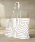 Side angle of large neutral printed weekender tote with soft rope handles