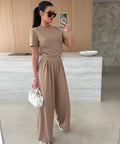 neutral two piece travel outfit featuring adjustable crop top and wide leg pants
