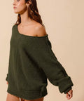 Angled view of olive slouchy off-shoulder bouclé sweater for women