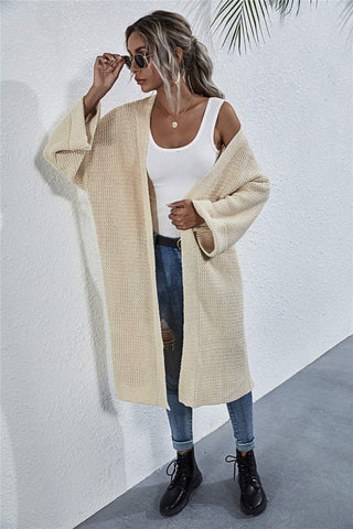 Model posing with hands in cardigan pockets