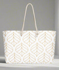 Gold leaf print weekender tote placed on white surface