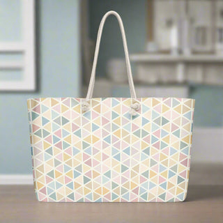 Weekender tote bag with pastel triangles placed on wooden table
