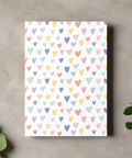 Flat lay of pastel multicolor hearts greeting card on marble background with greenery