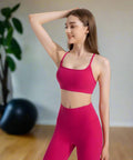 Lifestyle view of woman stretching with pink top