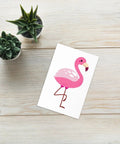 Pink Flamingo Greeting Card on a white table with green plant – envelope included