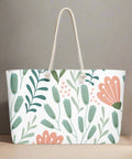 Large pink and green botanical print travel tote on a wooden surface