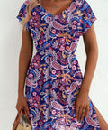 Woman wearing a colorful paisley dress  styled for the beach against a white background