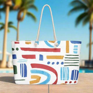 Bright abstract rainbow print tote by the pool with palm trees in the background