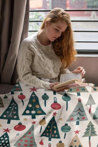 Woman reading with retro Christmas tree velveteen blanket