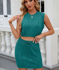 Woman posing in teal two-piece ribbed knit skirt and crop top set