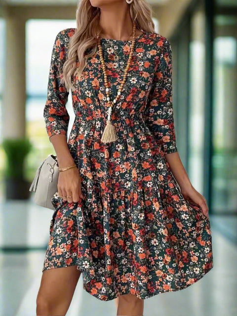 Woman wearing ruched floral dress with round neckline and 3/4 sleeves
