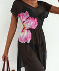 Black dress with a pink floral design worn by a person against a white background
