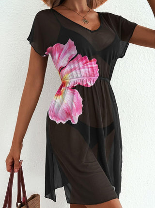 Black dress with a pink floral design worn by a person against a white background