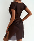Woman wearing a brown sheer coverup against a white background