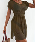 Woman wearing an olive green dress against a white background