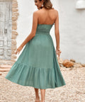 Side view of strapless sage smocked midi dress with flowy silhouette