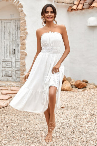 Woman wearing strapless smocked white midi dress with flowy skirt