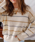 Casual spring outfit with cream striped drop shoulder sweater and light wash denim