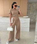 woman wearing tan matching crop top and wide leg pants vacation outfit