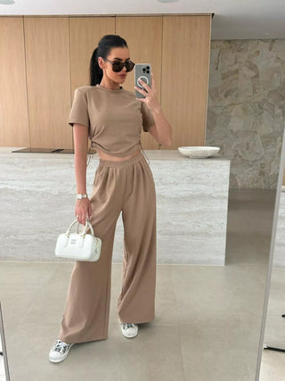woman wearing tan matching crop top and wide leg pants vacation outfit
