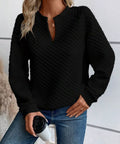 Front view of a black textured notched raglan sleeve sweatshirt with relaxed fit