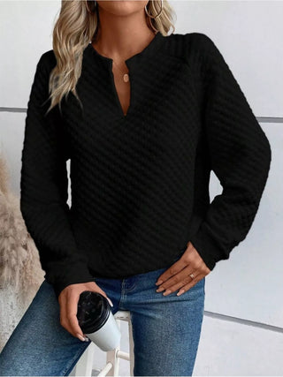 Front view of a black textured notched raglan sleeve sweatshirt with relaxed fit