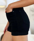 Side view of tummy control high-rise black shorts styled with a white tank.