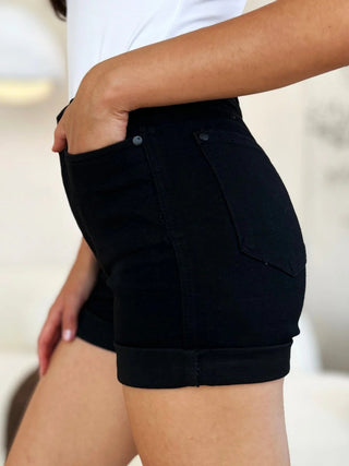Side view of tummy control high-rise black shorts styled with a white tank.