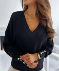 Woman wearing a black V-neck decorative button sweater with relaxed fit