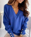 Woman wearing a royal blue V-neck lightweight sweater with button cuff detail