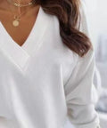 Close-up of white lightweight V-neck sweater with decorative cuff buttons