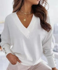 Woman wearing a white V-neck decorative button sweater styled for a spring outfit