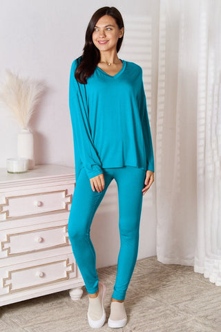Model wearing a blue V-neck long sleeve lounge set with matching pants, styled in a casual indoor setting.
