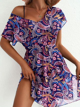 Woman wearing a colorful paisley dress against a white background