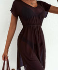 Woman wearing a dark brown dress against a white background
