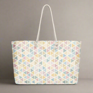 Pastel geometric weekender tote bag against grey backdrop