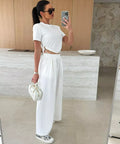 white matching two piece travel outfit featuring crop top and wide leg pants