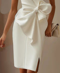 white wedding guest dress featuring oversized bow detail and elegant fitted silhouette