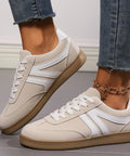 White lace-up sneakers featuring suede accents and rubber sole for casual everyday comfort.