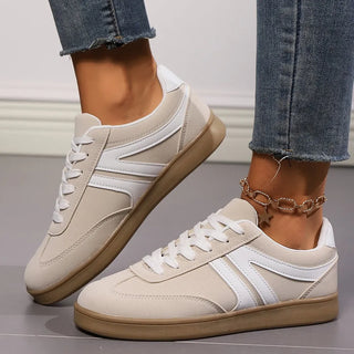 White lace-up sneakers featuring suede accents and rubber sole for casual everyday comfort.