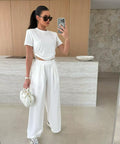 woman wearing white drawstring crop top and wide leg pants travel outfit set