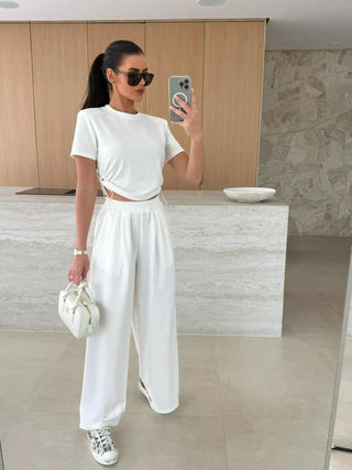 woman wearing white drawstring crop top and wide leg pants travel outfit set