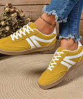 Yellow lace-up sneakers with suede finish and rubber outsole designed for comfortable everyday wear.