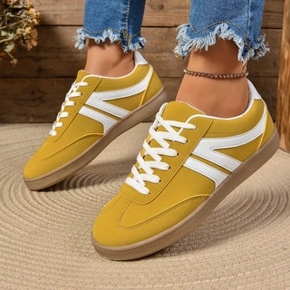 Woman wearing yellow lace-up sneakers styled with cropped denim jeans for a casual weekend outfit.