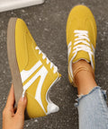 Yellow lace-up sneakers with white stripes and gum rubber sole for casual everyday style.