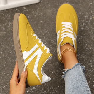 Yellow lace-up sneakers with white stripes and gum rubber sole for casual everyday style.